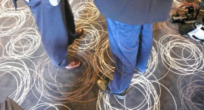 The carpet ripples around the feet of John Ruggie and Phil Clothier