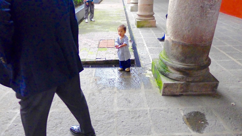 Small boy catching rainwater in his hands