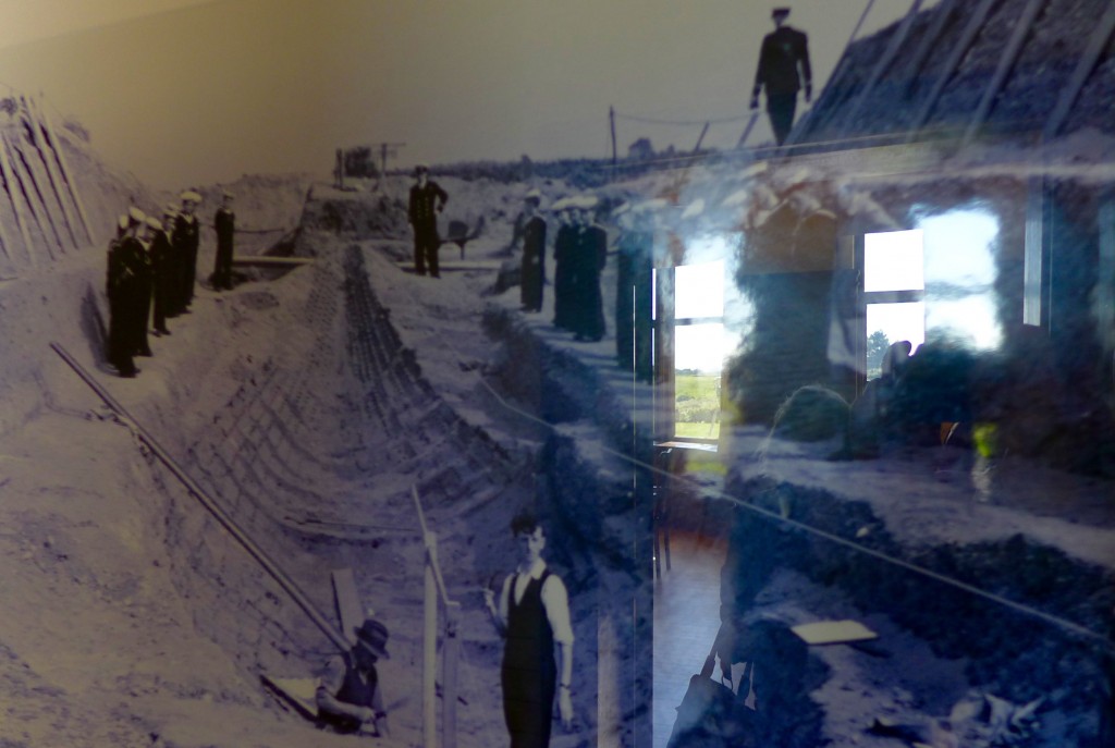 Photograph of ship burial dig, with tumuli hill reflected