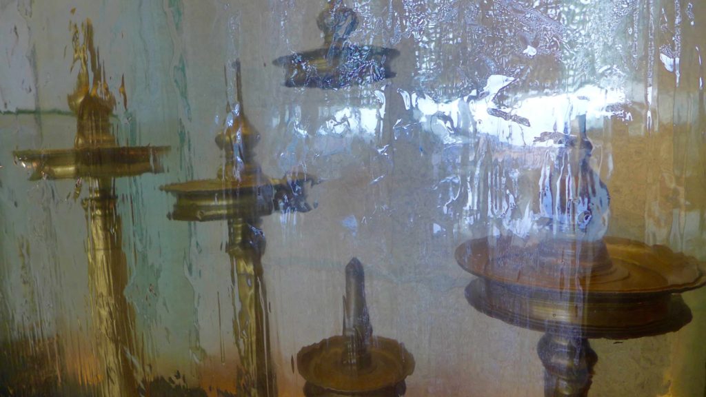 Temple oil lamps, behind glass symbolising ice